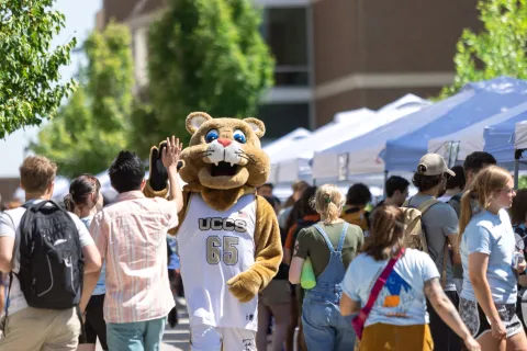 UCCS Mascot, Clyde, giving students a high five as they pass by him at Orientation.